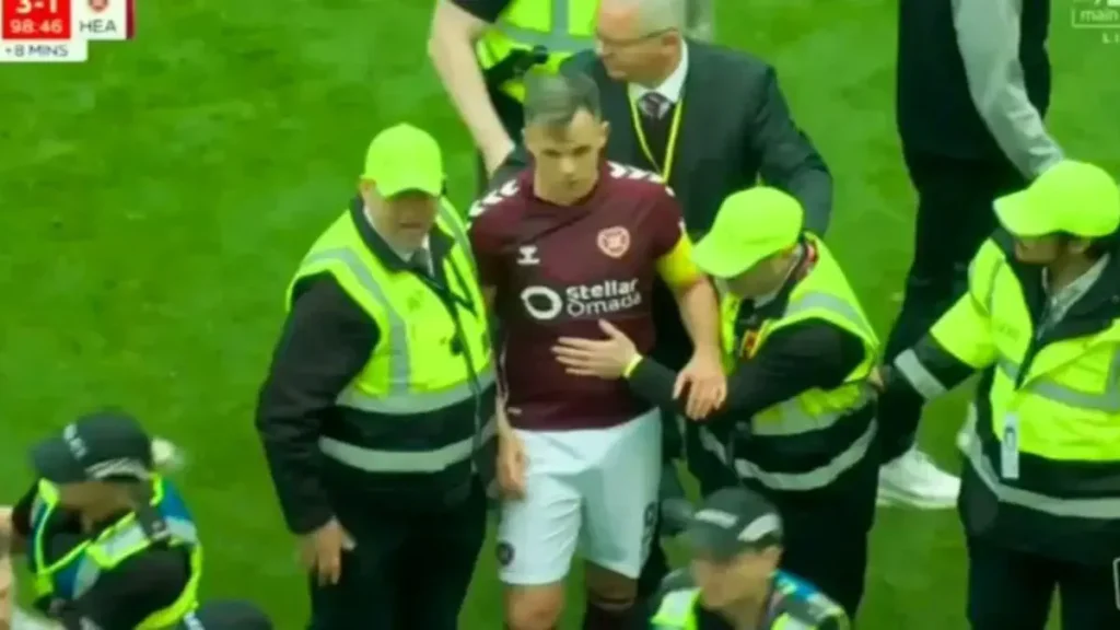 Celtic’s championship win sparks scandal as Hearts captain is attacked by fans on the pitch.